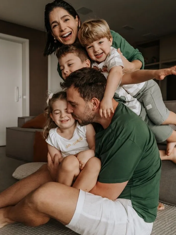Casal com os filhos se abraçando no sofá